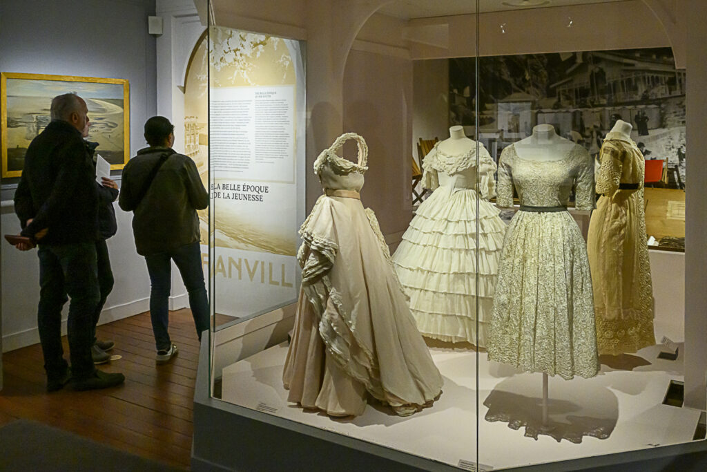 Visiteurs admirant les robes dans les vitrines